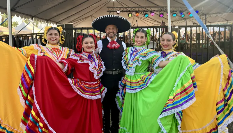 Ballet Folklórico Mi Herencia adult dancers in colorful Jalisco folklorico dresses with their instructor